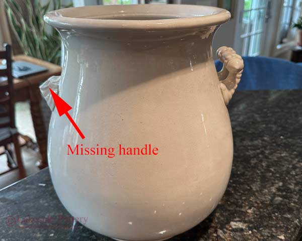 A large antique vase with a missing handle